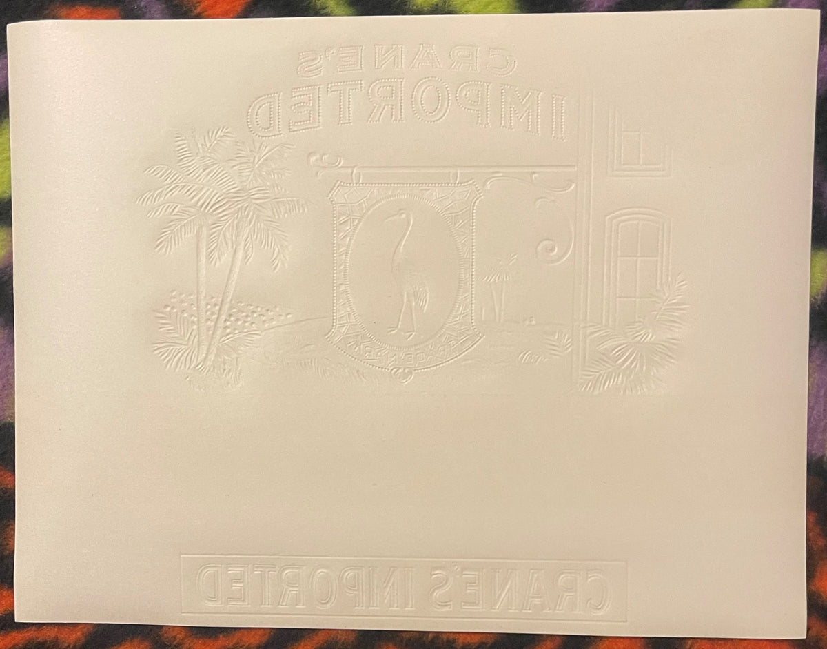 Cream-colored embossed cigar label with ornate border, central monogram, palm trees, and reversed