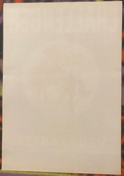Blank cream-colored vintage crate label on colorful patterned background, front side visible