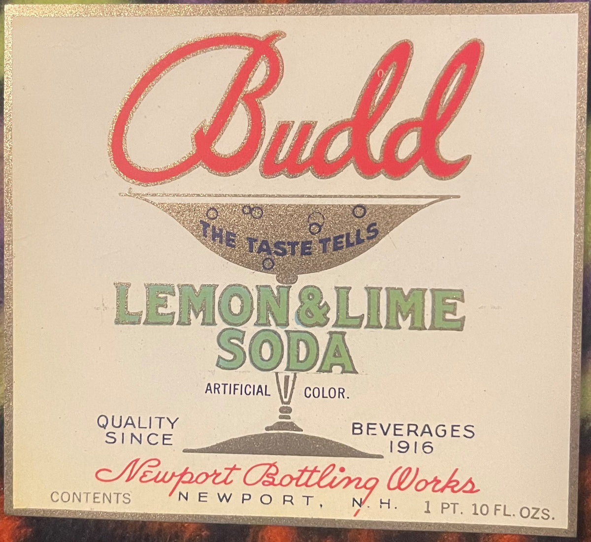 Vintage Budd brand lemon and lime soda label with red script lettering, gold and green accents, from Newport Bottling Works, 