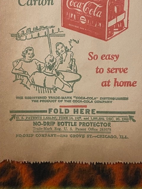 Vintage Coca-Cola no-drip bottle protector paper sleeve from Chicago, showing illustrated figures and red