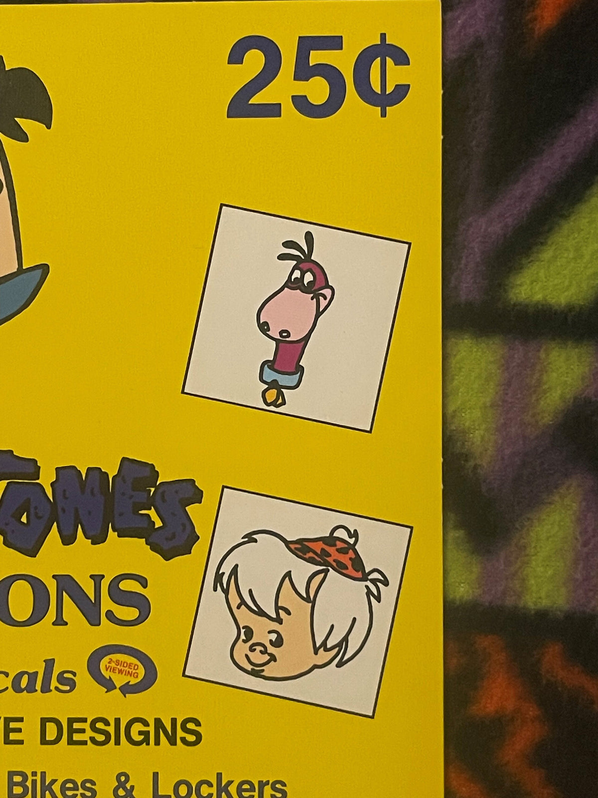 Yellow vintage vending sign showing 25¢ price with cartoon character illustrations and partial text mentioning Flintstones, J