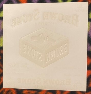 Embossed cream-colored cigar label showing "Corona" text in relief on white background