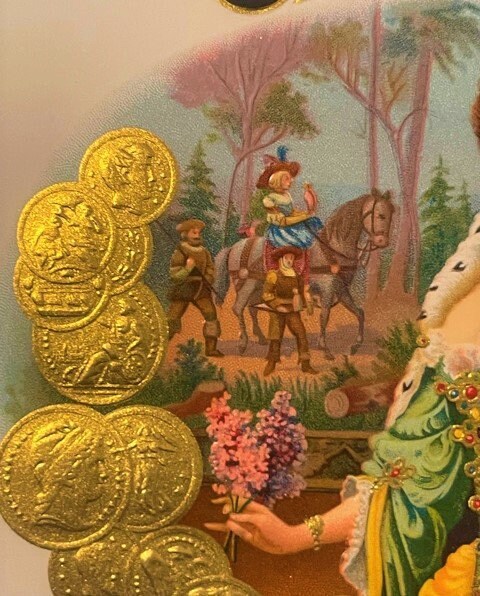 Gold embossed cigar label with Victorian scene of figures on horseback in forest, shown next to stacked gold coins for scale