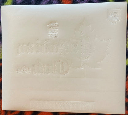 Cream-colored embossed cigar label with "Canadian Club" text, maple leaf design, and coat of arms, displayed flat against col