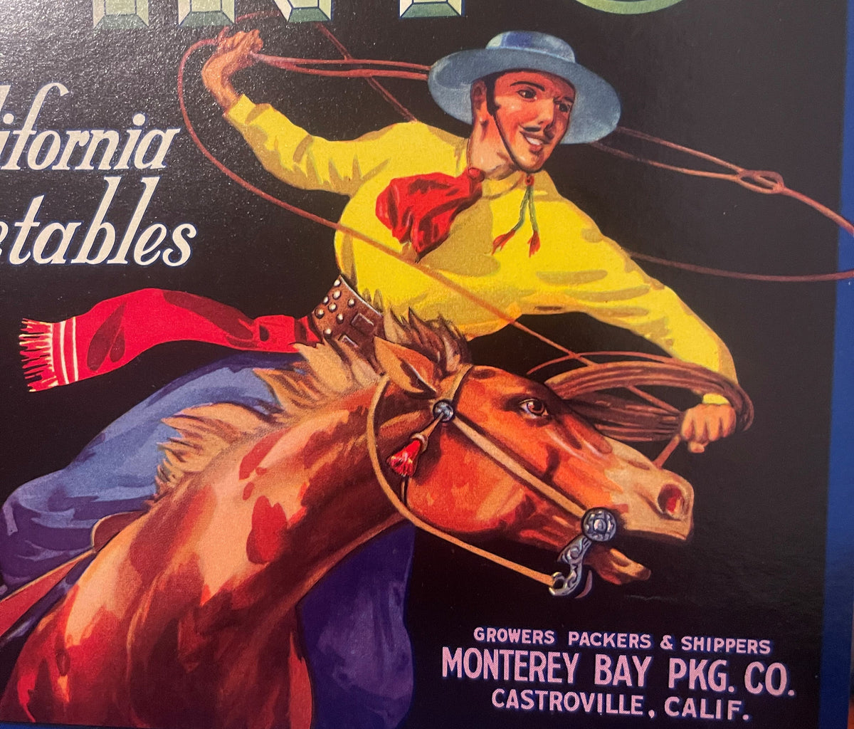 Vintage produce crate label featuring a cowboy in yellow shirt on a rearing horse with lasso, red text reading "Monterey Bay 