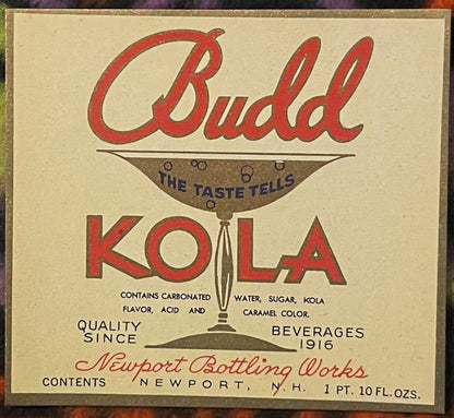 Vintage Budd Kola beverage label from Newport Bottling Works featuring red script text, brown illustration of a glass