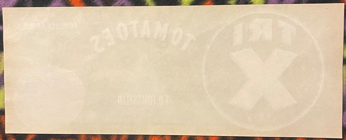 Cream-colored vintage crate label with faint embossed tomato imagery and text, displayed against a colorful patterned backgro