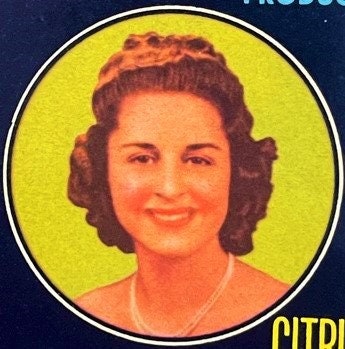 Vintage citrus crate label featuring a smiling woman's portrait in an oval frame against a bright yellow background, with "CI
