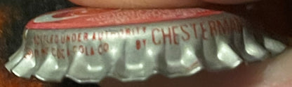 Vintage Cherry Coke bottle cap with red and white ridged crown, showing embossed text including "COKE" and partial lettering,