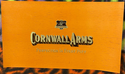 The medium Cornwall Arms label: gold-embossed lettering with a brown cast shadow on paper printed with an imitation wood-grain pattern, not an actual wood surface