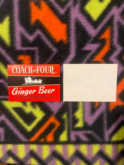 Vintage Coach and Four Ginger Beer label on colorful geometric patterned fabric background