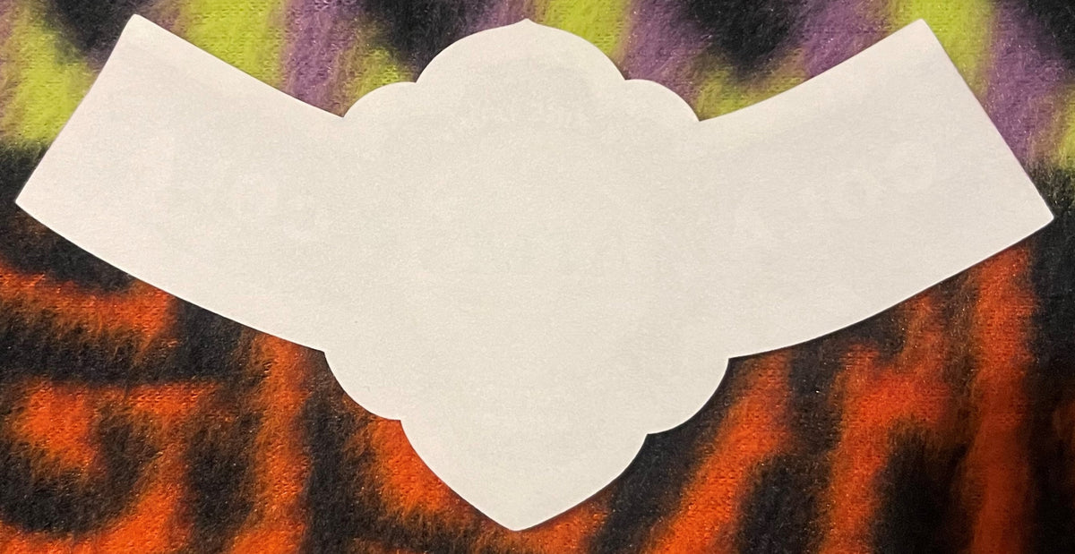 Cream-colored scalloped label on colorful striped background in orange, yellow, and purple tones