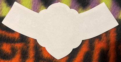 Cream-colored scalloped label on colorful striped background in orange, yellow, and purple tones