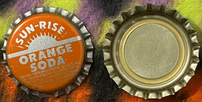 Front and back of vintage Sun-Rise Orange Soda bottle cap with ridged metal edges and white lettering on orange, displayed on