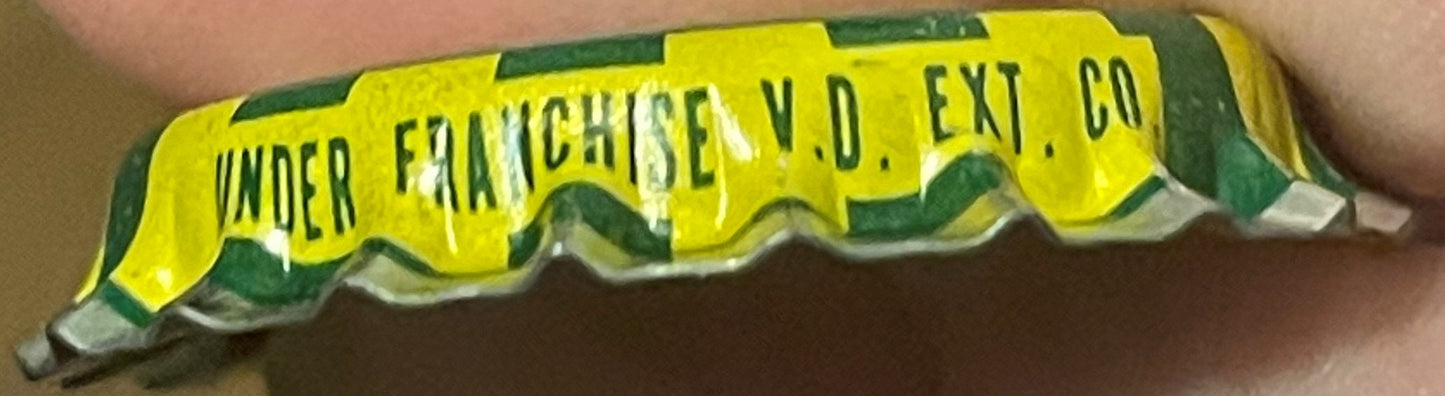 Vintage yellow and green korker bottle cap held in hand, printed text reads "Under Franchise N.D. Ent. Co