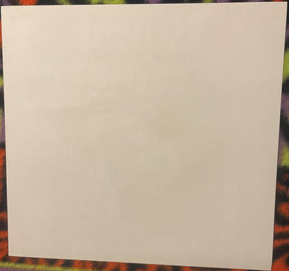 Blank cream-colored paper or card displayed against a colorful patterned background