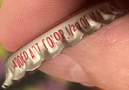 Vintage Cherry Smash bottle cap held in hand showing red text and cream-colored metal cap, close-up detail view