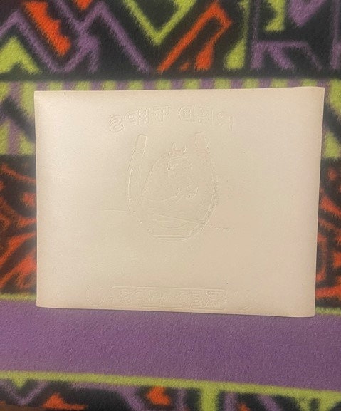 Back of the Red Tips cigar label: plain paper with the horseshoe, the horse's head and the RED TIPS lettering embossed through in reverse