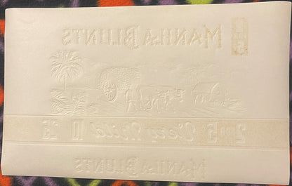 Cream-colored embossed cigar label with "Manila Blunts" text at top and bottom, tropical scene with palm trees and ornate car