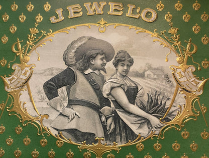 Antique Jewelo cigar label with gold embossed border, green background, and central engraving of a man and woman in period dr