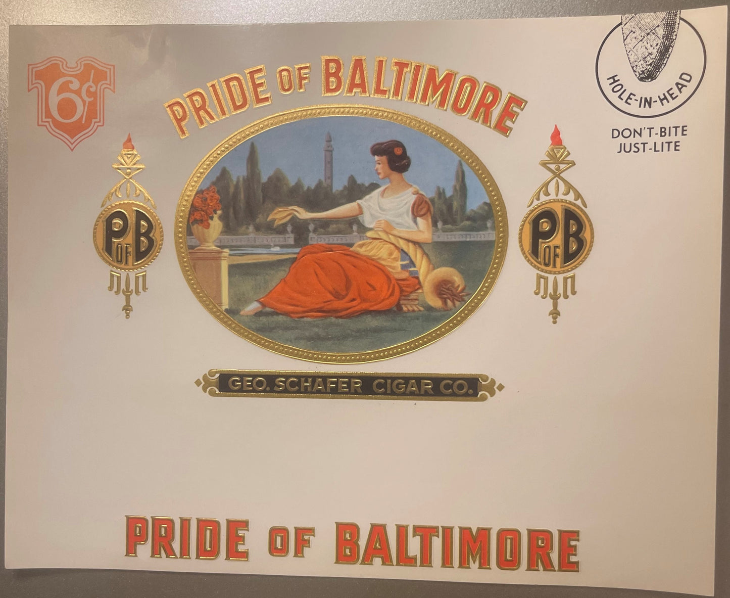 Vintage cigar label with gold foil embossing showing a woman in classical dress by a waterfront, "Pride of Baltimore" text, a