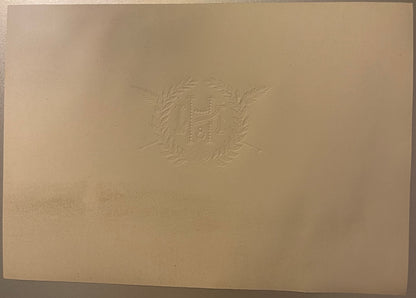 Back of the N&H cigar label: plain cream paper with the monogram, wreath and crossed shafts embossed in reverse