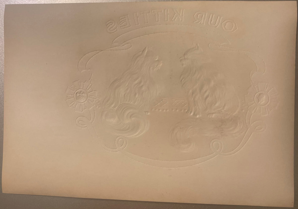 Cream-colored embossed cigar box label with two ornate cats and decorative flourishes, text reading "Our Kitties" at top, vie