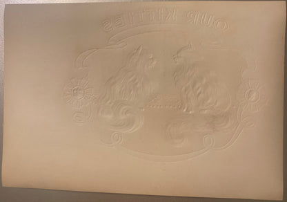 Cream-colored embossed cigar box label with two ornate cats and decorative flourishes, text reading "Our Kitties" at top, vie