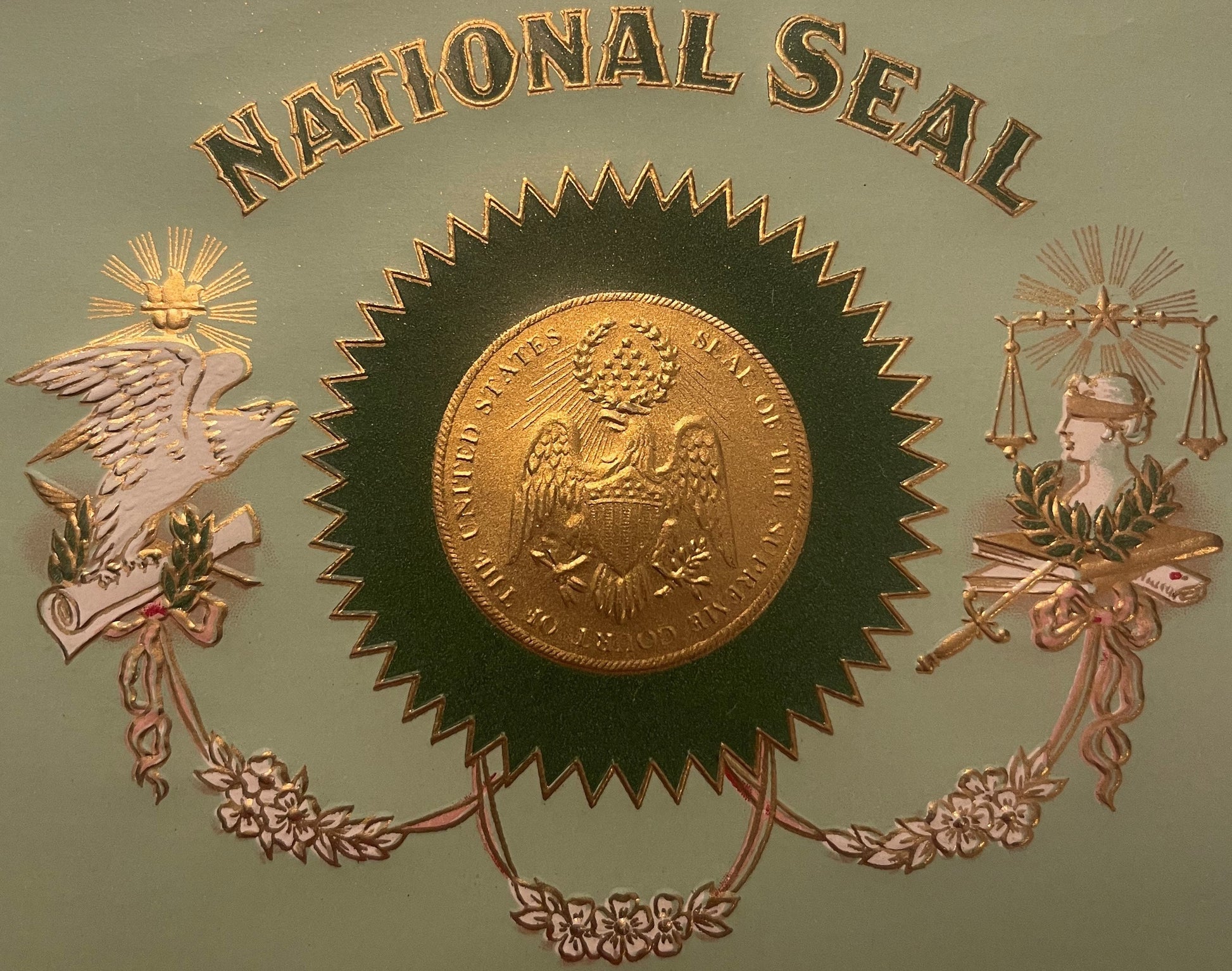 Embossed cigar label with "National Seal" text, central gold coin on dark rosette, flanked by winged eagle and Lady Justice s