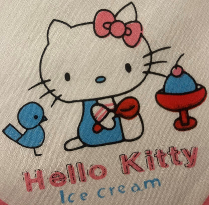 Vintage Hello Kitty cotton napkin with pink bow, blue dress, red shoes, and "Hello Kitty ice cream" text on beige fabric