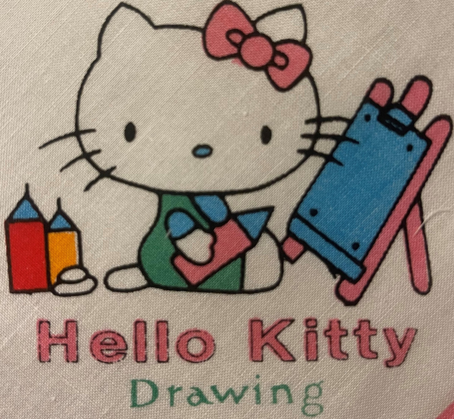 Vintage Hello Kitty cotton napkin with printed illustration of character holding blocks, wearing pink bow and blue outfit, on