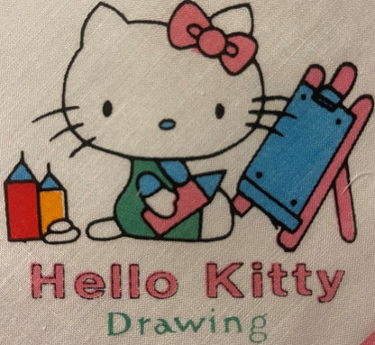 Vintage Hello Kitty cotton napkin with printed illustration of character holding blocks, wearing pink bow and blue outfit, on