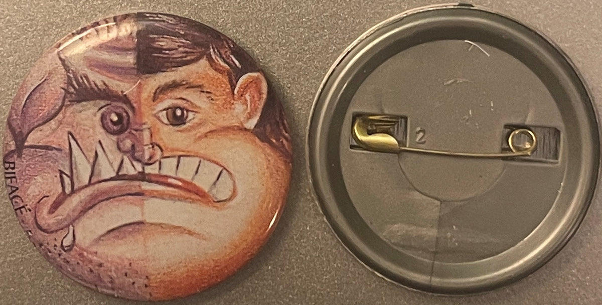Vintage pin-back button showing split two-faced character design with monster and boy features in purple and peach tones, dis