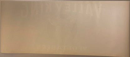 Cream-colored vintage vegetable crate label with faded printing, photographed flat against neutral background