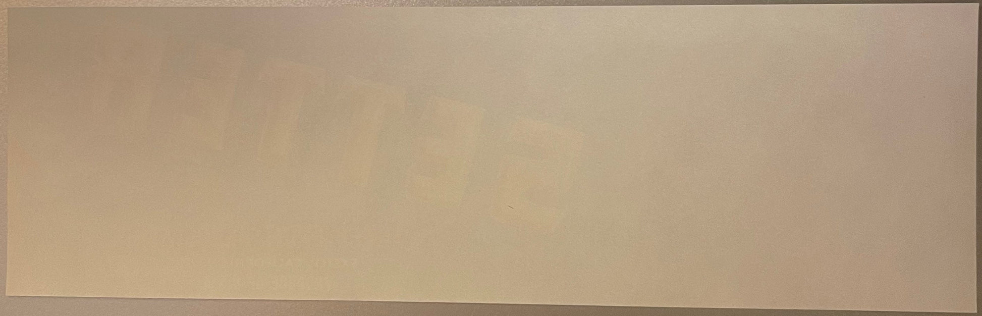 Blank tan-colored vintage crate label with subtle wood grain texture, photographed flat against neutral background