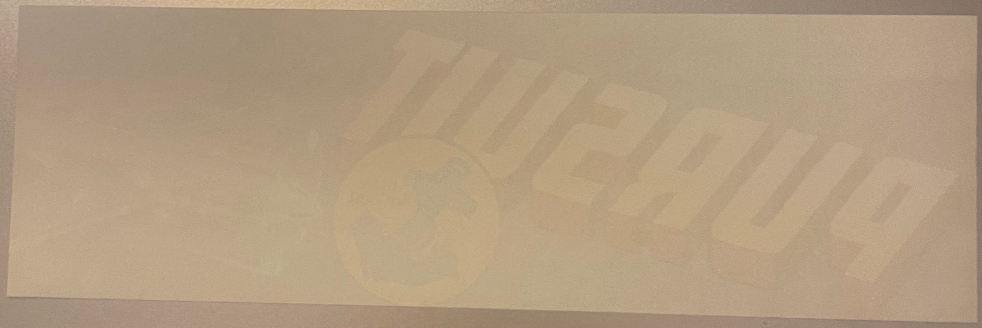 Faded vintage crate label with embossed or debossed text reading "Pursuit" and partial imagery, cream-colored paper on neutra