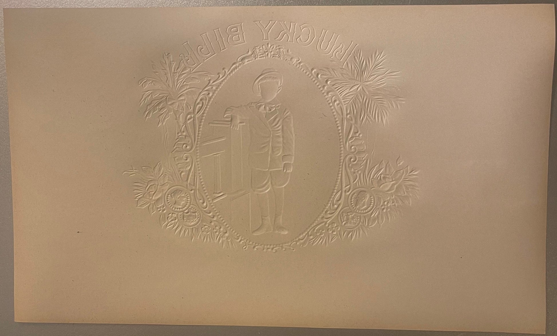 Embossed cream-colored cigar label featuring ornate Victorian frame with botanical flourishes surrounding central profile of 