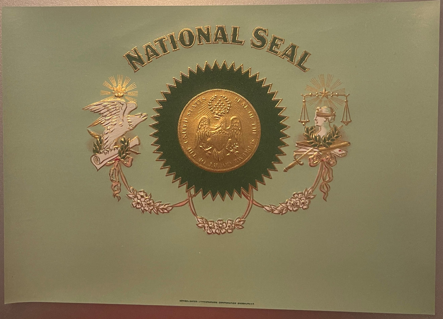 Embossed antique cigar label with "National Seal" text, gold coin center, and allegorical figures flanking scales of justice 