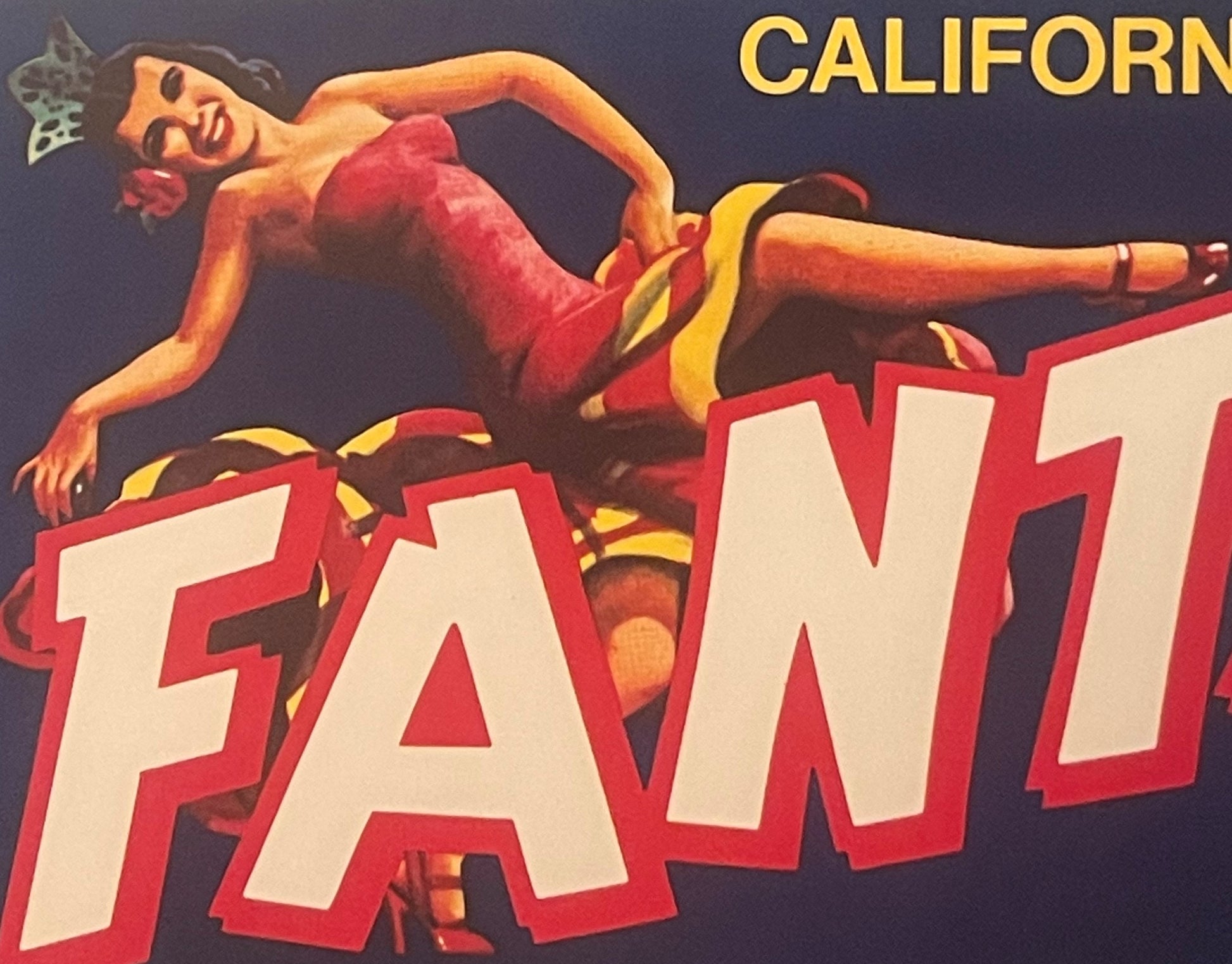 Vintage fruit crate label featuring a reclining woman in red dress with yellow accents against dark blue background, large re