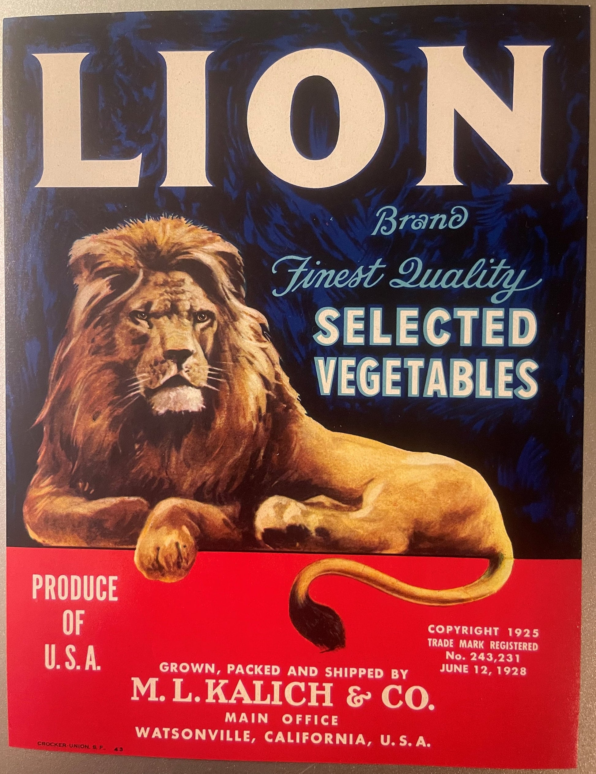 Vintage Lion Brand vegetable crate label featuring a majestic lion's head against dark blue background, with red banner below
