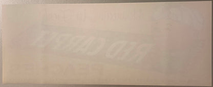 Blank peach crate label with faint watermark text visible against beige background, photographed flat