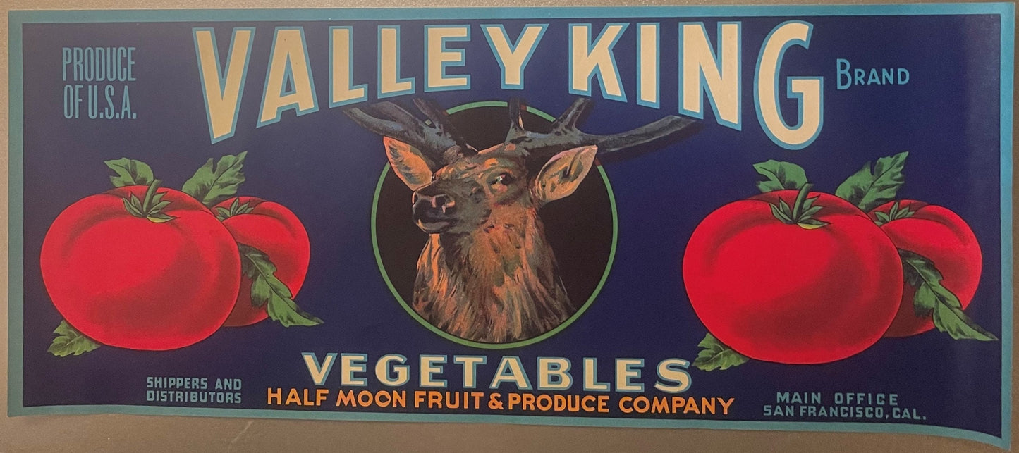 Vintage produce crate label featuring a deer head centered between red tomatoes on dark blue background, gold lettering readi