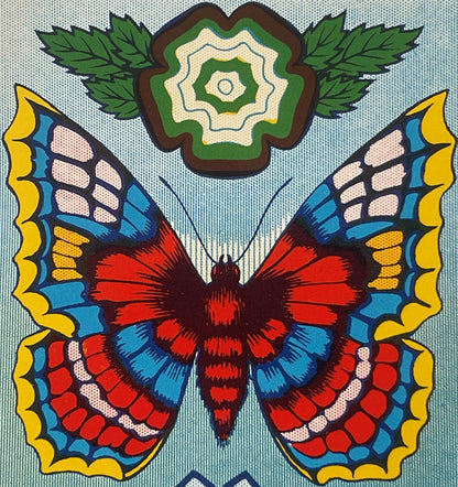 Vintage lithograph label featuring a symmetrical butterfly with red and dark body, blue and yellow-edged wings, green leafy f