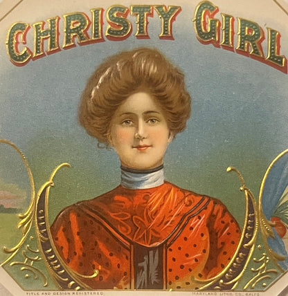 Vintage chromolithograph cigar label with "Christy Girl" text, featuring portrait of woman in red dress with brown hair and w