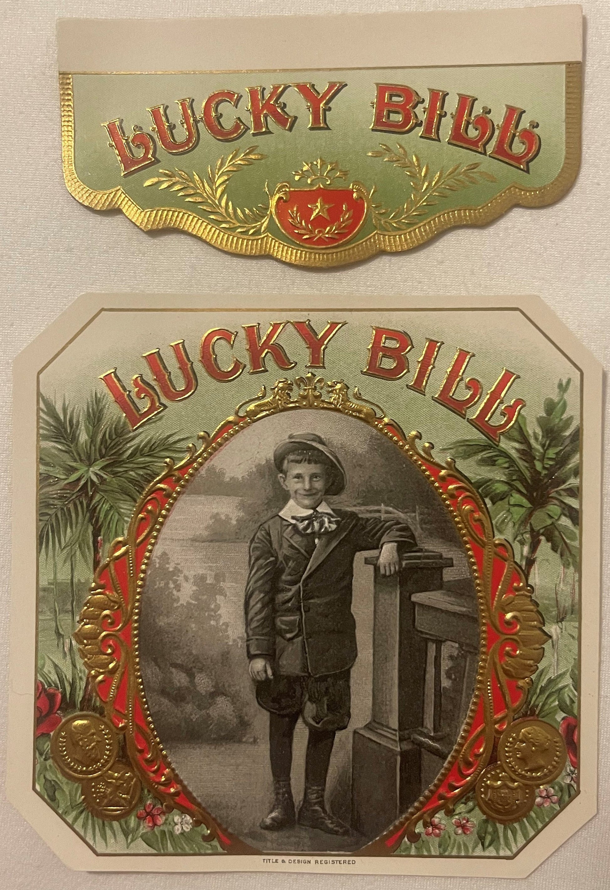 Two vintage Lucky Bill cigar box labels with embossed gold edges, red text, ornamental borders, and a central portrait of a y