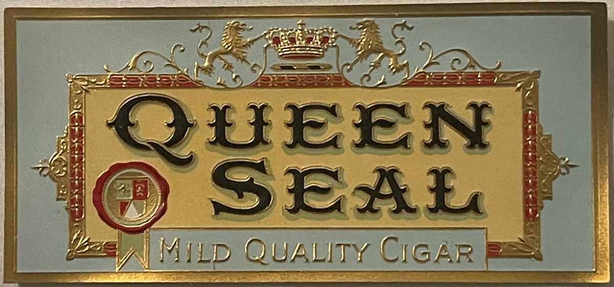 Gold embossed cigar box label reading "Queen Seal" with royal crown and shield, marked "Mild Quality Cigar," on cream and blu