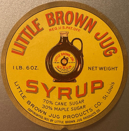 Circular yellow syrup label with red text showing a brown jug bottle, 1 lb 6 oz net weight, 70% cane sugar and 30% maple suga