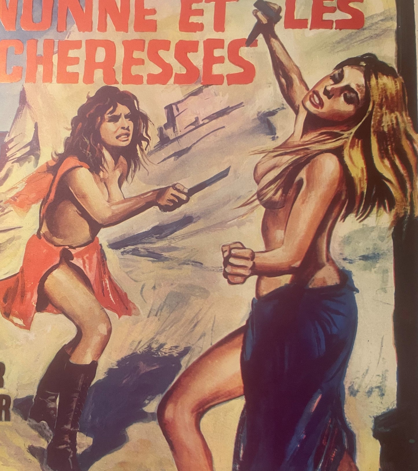 Vintage movie poster with red text header, featuring two women in minimal clothing in fighting poses against a desert backgro