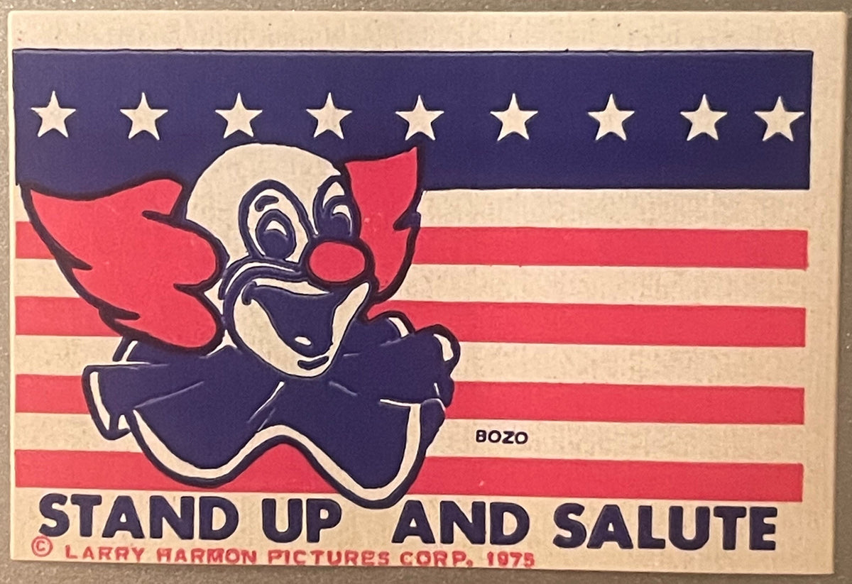 Vintage 1975 Bozo the Clown sticker on American flag background with stars and stripes, text reads "Stand Up and Salute