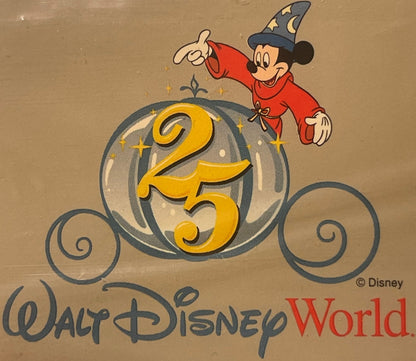 Vintage Walt Disney World 25th Anniversary Sorcerer Mickey luggage label showing Mickey in red robe and wizard hat on tan car